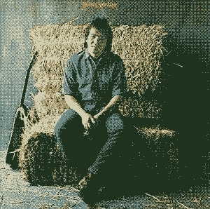 The album cover for John Prine's self-titled debut album. The cover is a photograph of Prine dressed in a blue work shirt, blued jeans, and leather boots looking at the camera while he sits on a chair fashioned from several bales of hay. His guitar is leaned against the hay bales to his right.